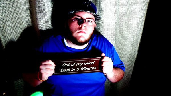 Christo holding an “Out of my mind / Back in 5 Minutes” sign