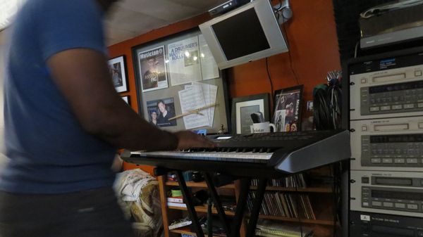 Keyboard player at a synth in the control room